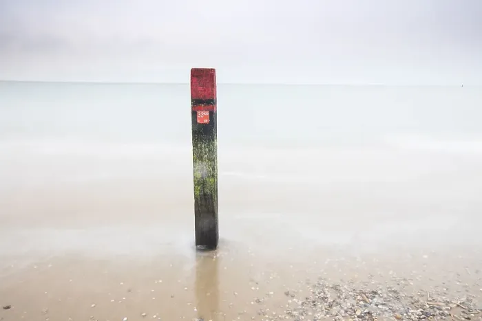 Framed Print : Landmark. Pole on the beach of Texel
